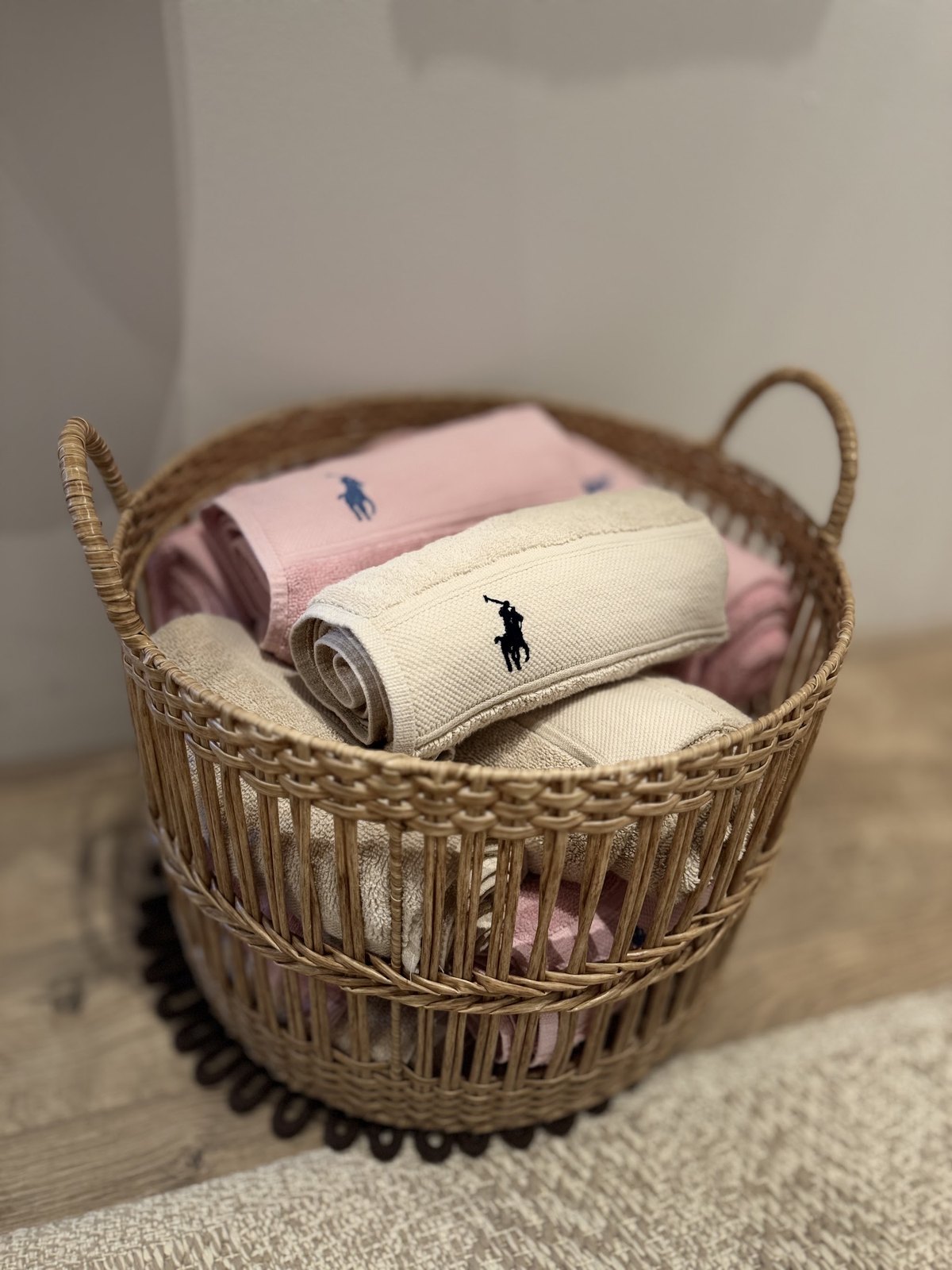 Rieten mand met opgerolde roze en crème handdoeken