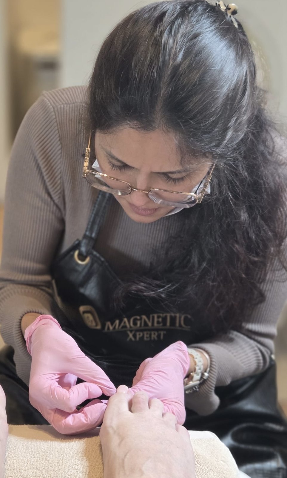 Dulce aan het werk tijdens een pedicure, met roze handschoenen